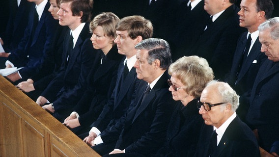 Trauerfeier für den ermordeten Hanns Martin Schleyer: Bundeskanzler Helmut Schmidt sitzt zwischen Sohn Hanns-Eberhard Schleyer und Witwe Waltrude Schleyer, rechts neben ihr Bundespräsident Walter Scheel. ©  picture-alliance/ dpa Foto: Heinz Wieseler