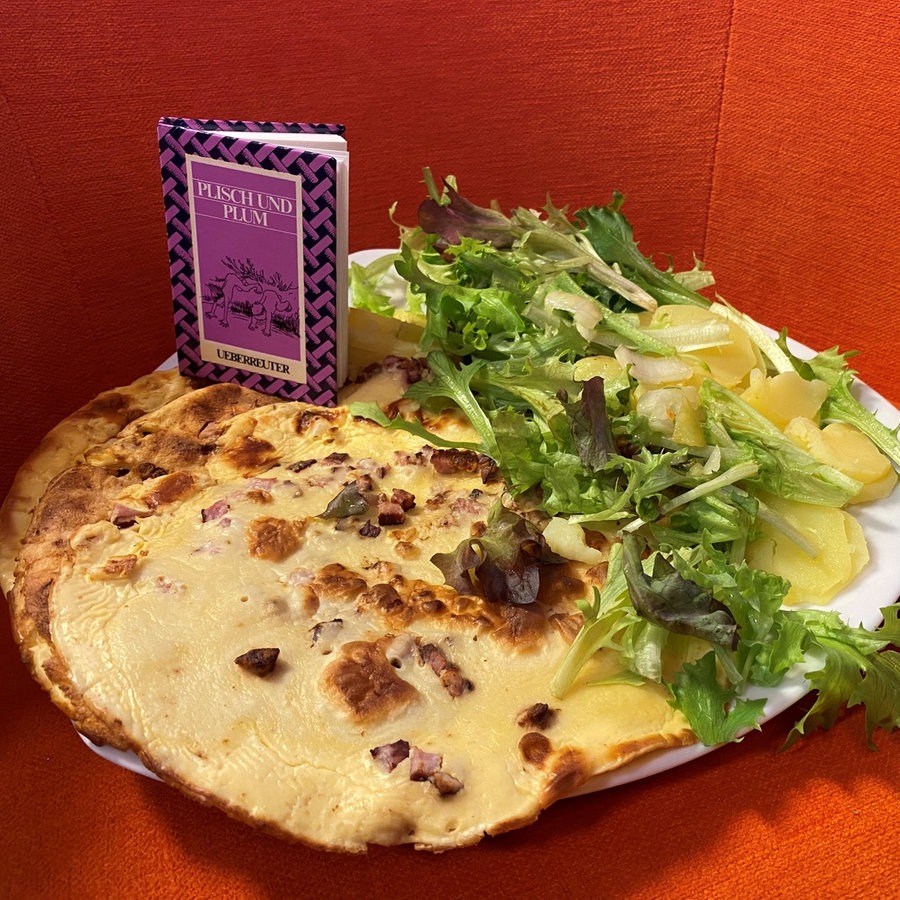 Zwei Bücher von Wilhelm Busch und ein Teller Pfannkuchen mit Salat  