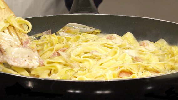 Tagliatelle mit Chicorée und Schinken-Sahnesoße in einer Pfanne © NDR 