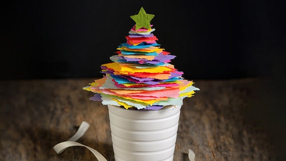 Ein Weihnachtsbaum aus bunten Papierresten steht in einer Konservendose. © Imago Foto: Magdalena Iordache